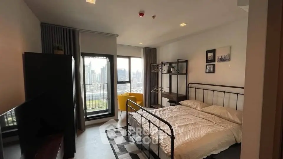 Modern bedroom with city view, featuring a cozy bed, stylish decor, and a private balcony for urban living.