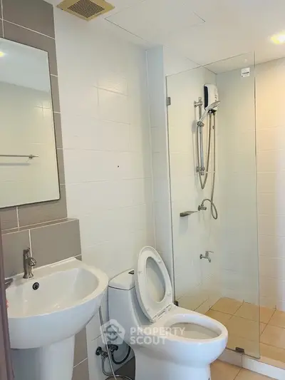 Modern bathroom with glass shower and white fixtures in a contemporary apartment.