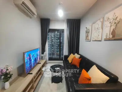Modern living room with sleek black sofa and city view window, perfect for urban living.