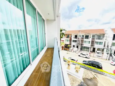 Spacious balcony with modern glass railing and city view, perfect for relaxation and enjoying the outdoors.