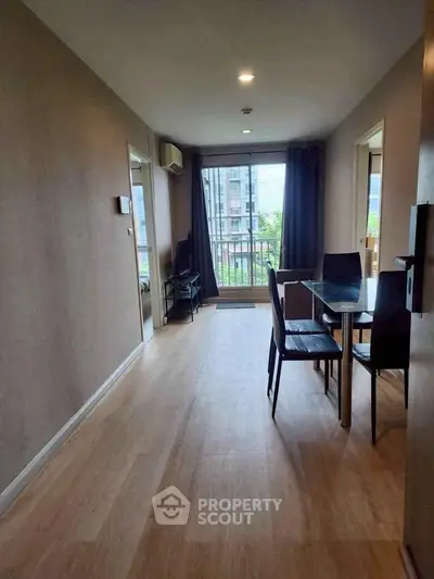 Spacious living room with dining area and balcony view in modern apartment.