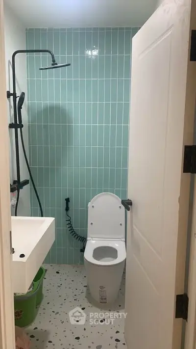 Modern bathroom with stylish green tiles and contemporary fixtures.