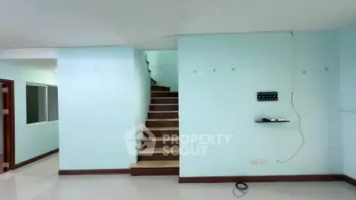 Spacious interior with modern staircase and light blue walls, ideal for contemporary living.