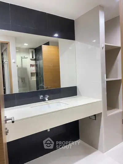 Modern bathroom with sleek design and spacious vanity in a contemporary apartment.
