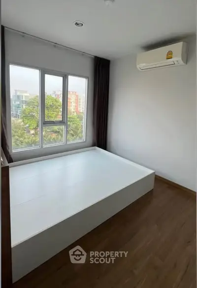 Modern bedroom with large window and air conditioning in urban apartment