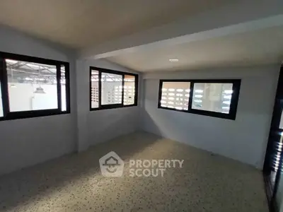 Spacious room with large windows and terrazzo flooring, ideal for versatile use.