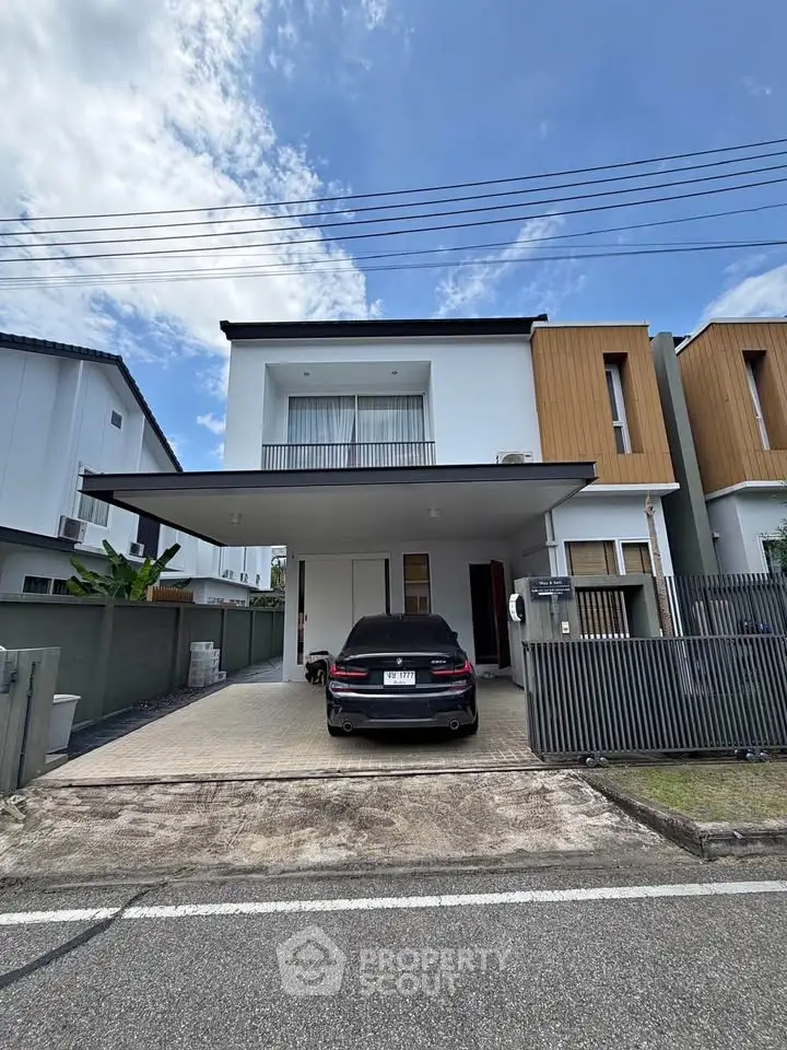 Modern two-story house with carport and sleek exterior design in a suburban neighborhood.