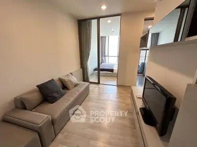 Modern living room with sleek design and cozy atmosphere, featuring a comfortable sofa and flat-screen TV.