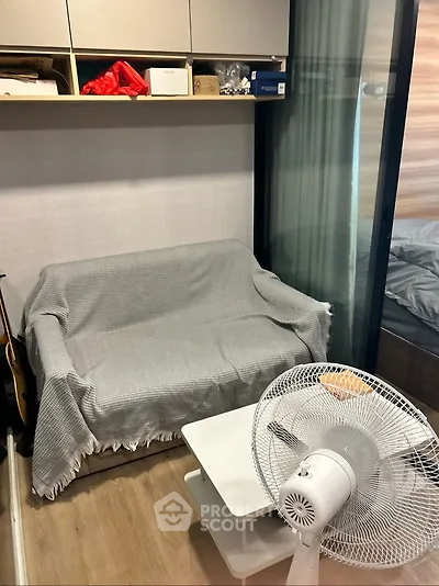 Cozy small living area with sofa, fan, and modern decor