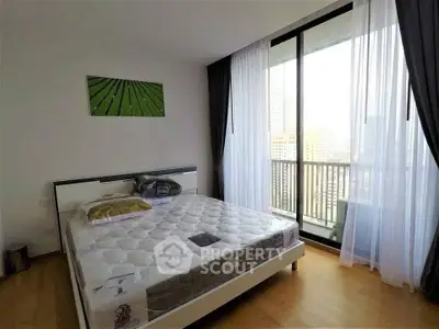 Modern bedroom with large window and city view, featuring a comfortable bed and stylish decor.