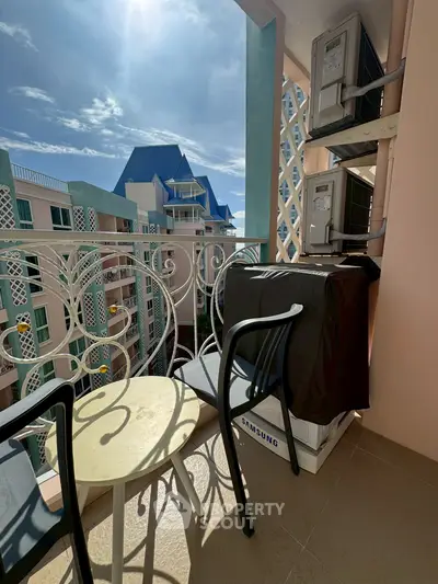 Charming balcony with seating and scenic view in modern apartment complex.