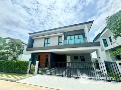 Modern two-story house with sleek design and spacious driveway in a serene neighborhood.