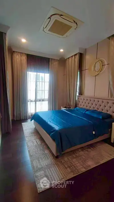 Luxurious bedroom with elegant decor and large window for natural light.