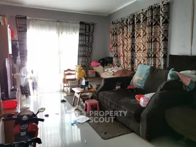 Spacious living room with cozy sofa and large windows, perfect for family gatherings.