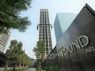 Modern high-rise building with lush landscaping and sleek architectural design.