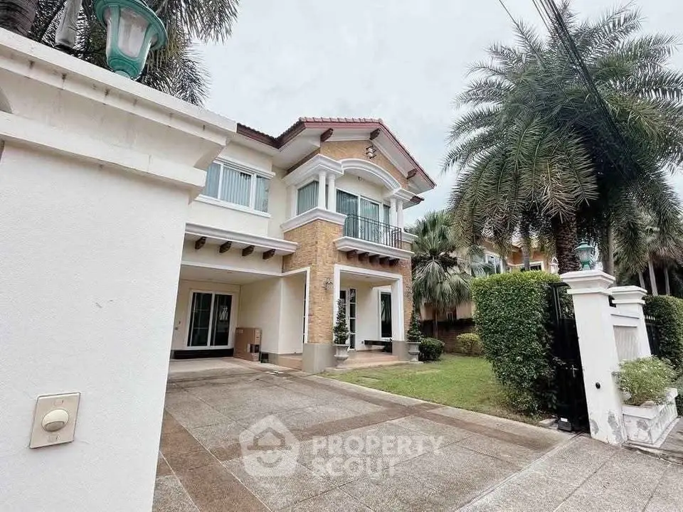 Elegant two-story house with lush garden and spacious driveway in a serene neighborhood.