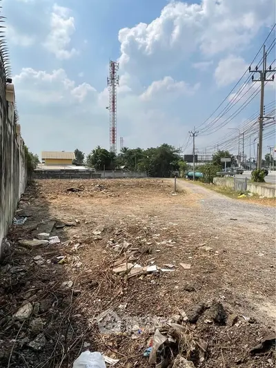Vacant land plot with potential for development, surrounded by urban infrastructure and clear skies.