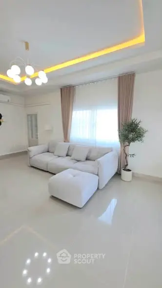 Spacious modern living room with elegant lighting and plush white sofa, perfect for relaxation.