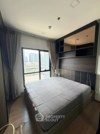 Modern bedroom with large window and city view, featuring stylish built-in shelves and cozy ambiance.