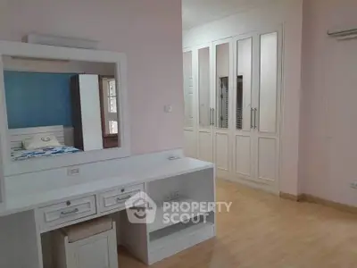 Spacious bedroom with built-in wardrobe and elegant vanity in modern home