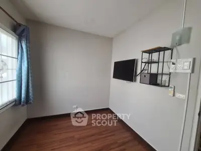 Minimalist room with wooden flooring and wall-mounted TV, perfect for a cozy living space.