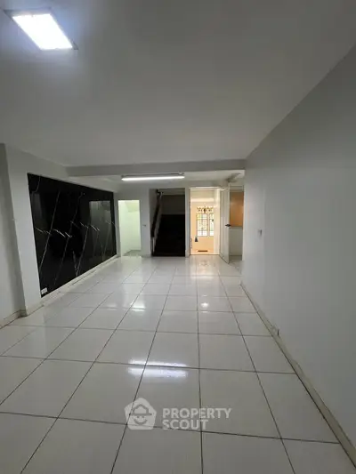 Spacious modern interior with sleek tile flooring and contemporary design, ideal for versatile living spaces.