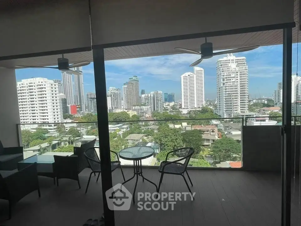 Stunning cityscape view from a modern balcony with outdoor seating.