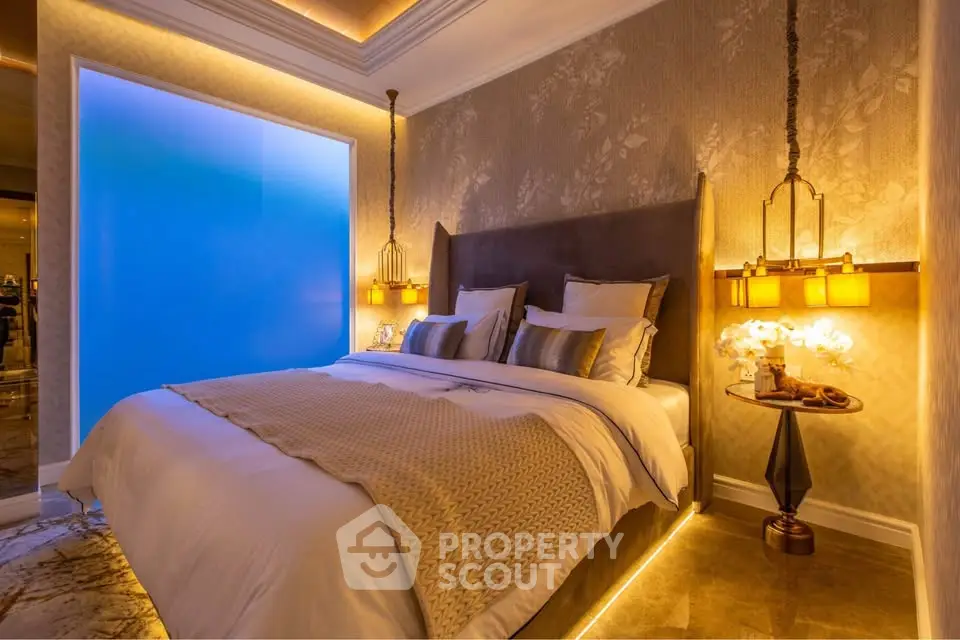 Luxurious bedroom with elegant lighting and plush bedding in a modern apartment.