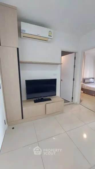 Modern living room with sleek TV setup and air conditioning in a stylish apartment.