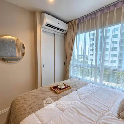 Cozy bedroom with modern decor and large window offering city view, featuring air conditioning and elegant curtains.