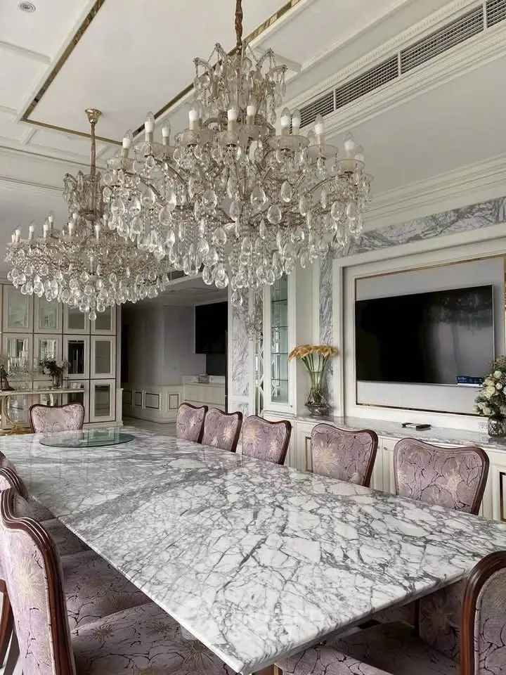 Luxurious dining room with marble table and crystal chandeliers in elegant home