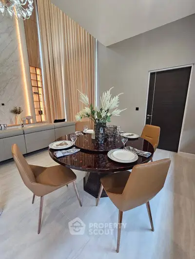 Elegant dining area with modern round table and stylish chairs in luxurious interior setting.
