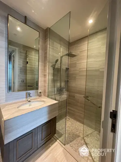 Modern bathroom with glass shower and elegant vanity in luxury home