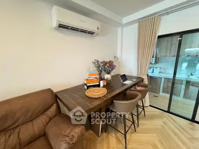 Modern living area with stylish furniture and kitchen view, perfect for urban living.