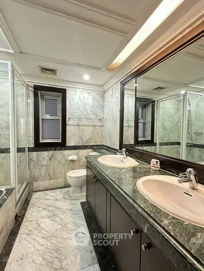 Luxurious marble bathroom with dual sinks and elegant fixtures
