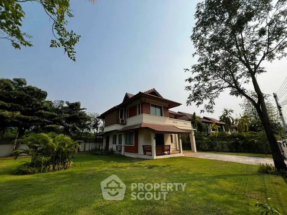 Charming two-story house with lush green lawn and mature trees, perfect for serene living.