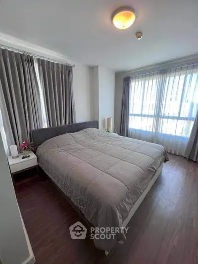 Cozy bedroom with large windows and elegant curtains in modern apartment