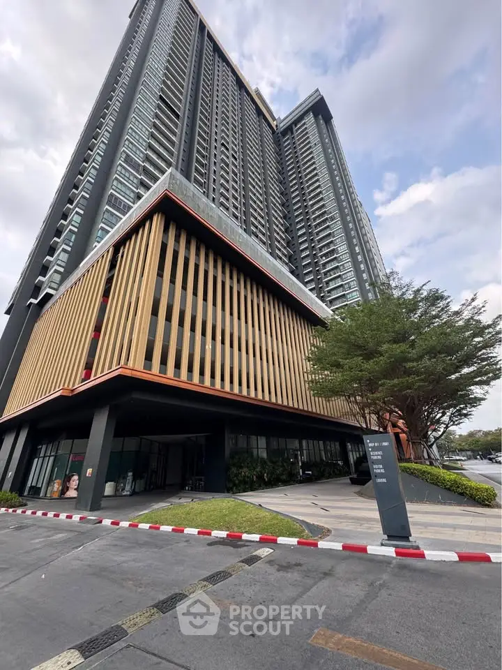 Modern high-rise building with unique architectural design and lush greenery