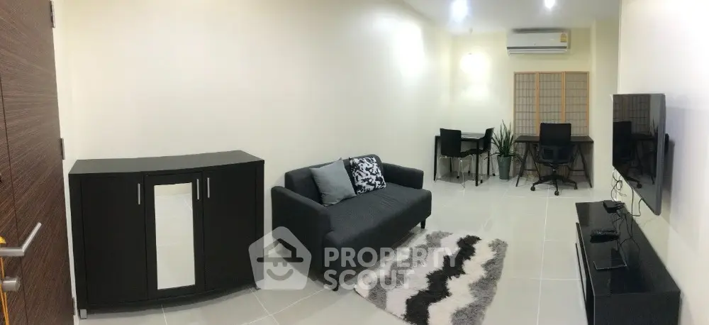 Modern living room with sleek furniture and stylish decor, featuring a cozy sofa and a chic rug.