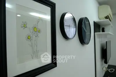 Modern interior with wall art, clocks, and air conditioning unit in a stylish living space.