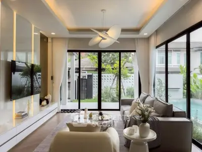 Luxurious living room with modern decor and pool view, featuring elegant furniture and large windows.