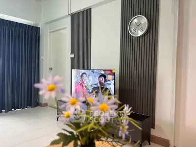 Modern living room with stylish wall paneling and TV, featuring elegant decor and a cozy atmosphere.
