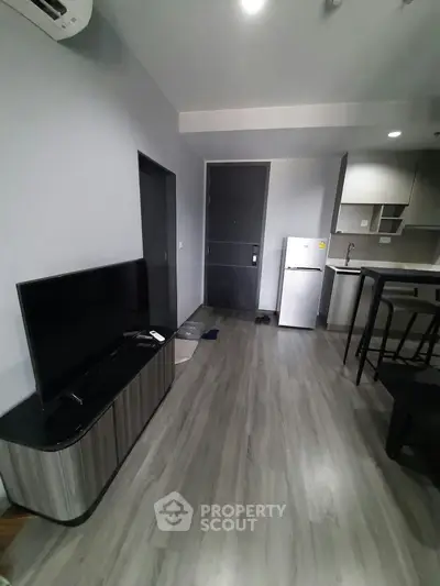 Modern apartment interior with sleek kitchen and cozy living area, featuring stylish flooring and contemporary furniture.