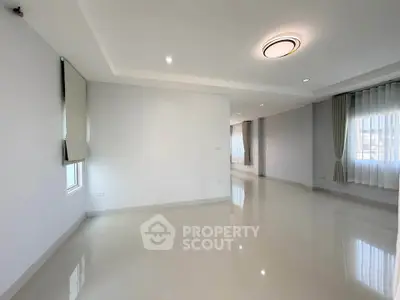 Spacious modern living room with large windows and sleek lighting