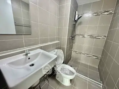 Modern bathroom with sleek tiles and contemporary fixtures in a stylish real estate property.