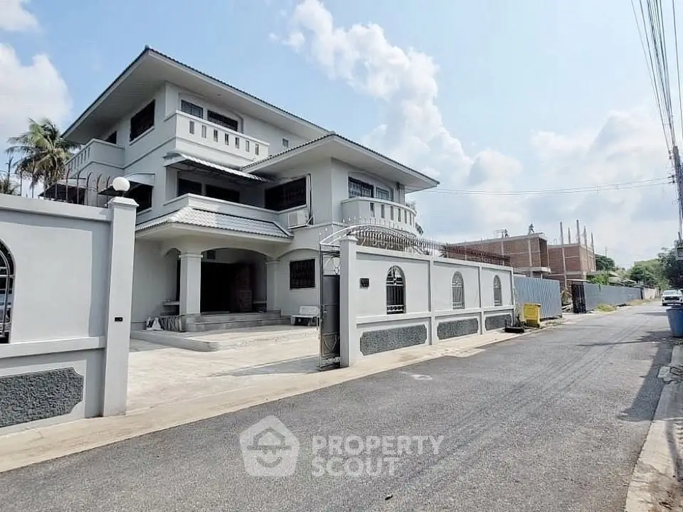 Stunning three-story residential building with elegant facade and spacious driveway.