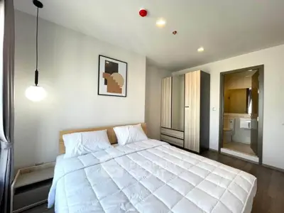 Modern bedroom with stylish decor and ensuite bathroom in a contemporary apartment.