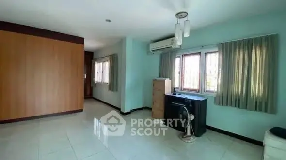 Spacious room with large windows and air conditioning unit, ideal for versatile use.