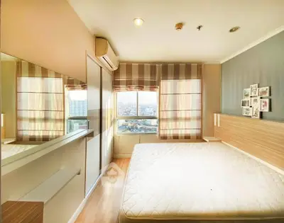 Bright and airy bedroom with large windows and city view, featuring modern decor and ample natural light.