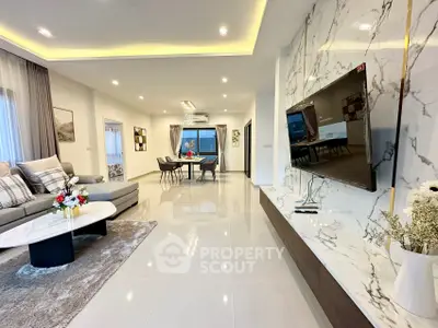 Luxurious modern living room with marble accents and open dining area, perfect for entertaining.